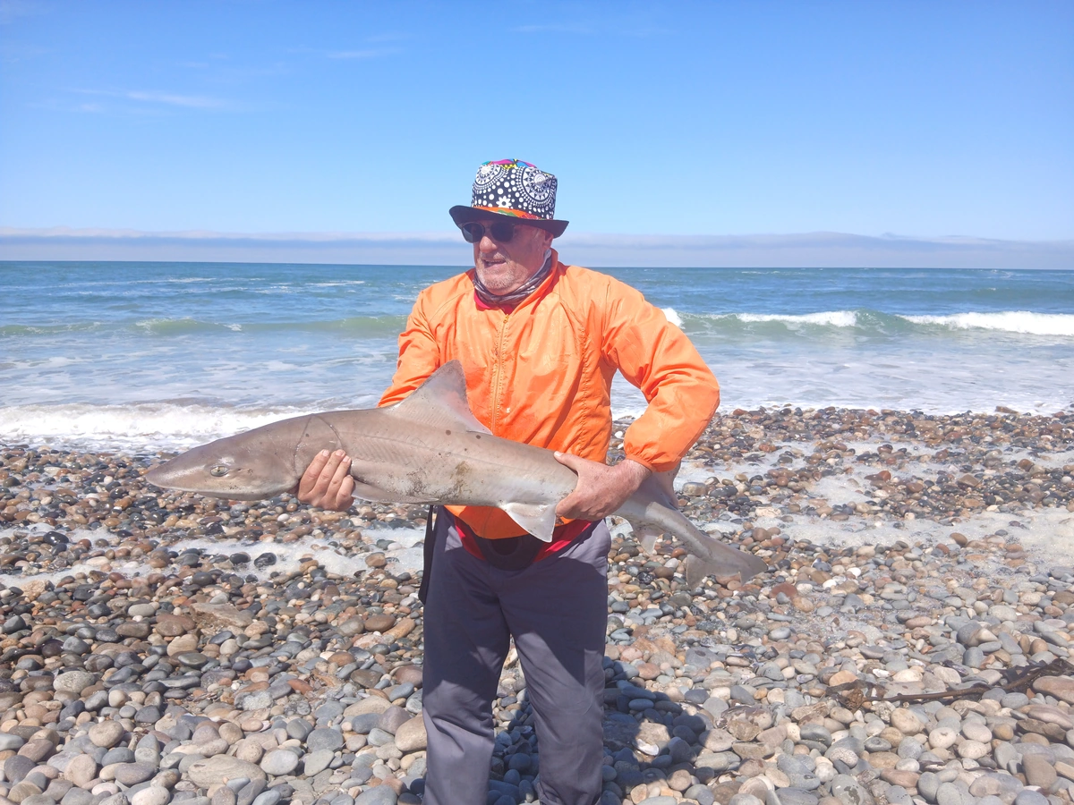 Client holding a fish after a successful guided shore fishing session