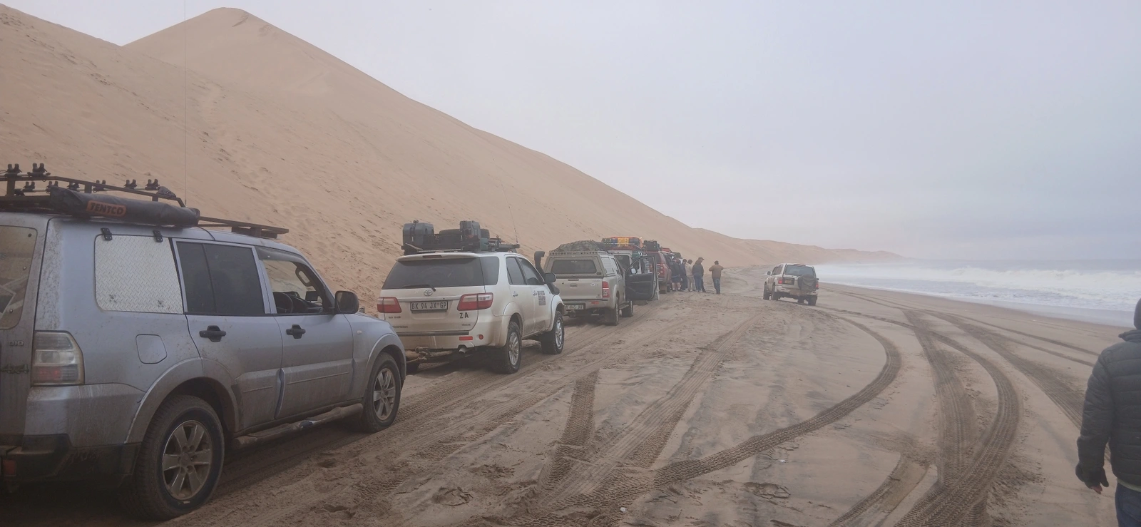 4x4 convoy travelling beside a large dune