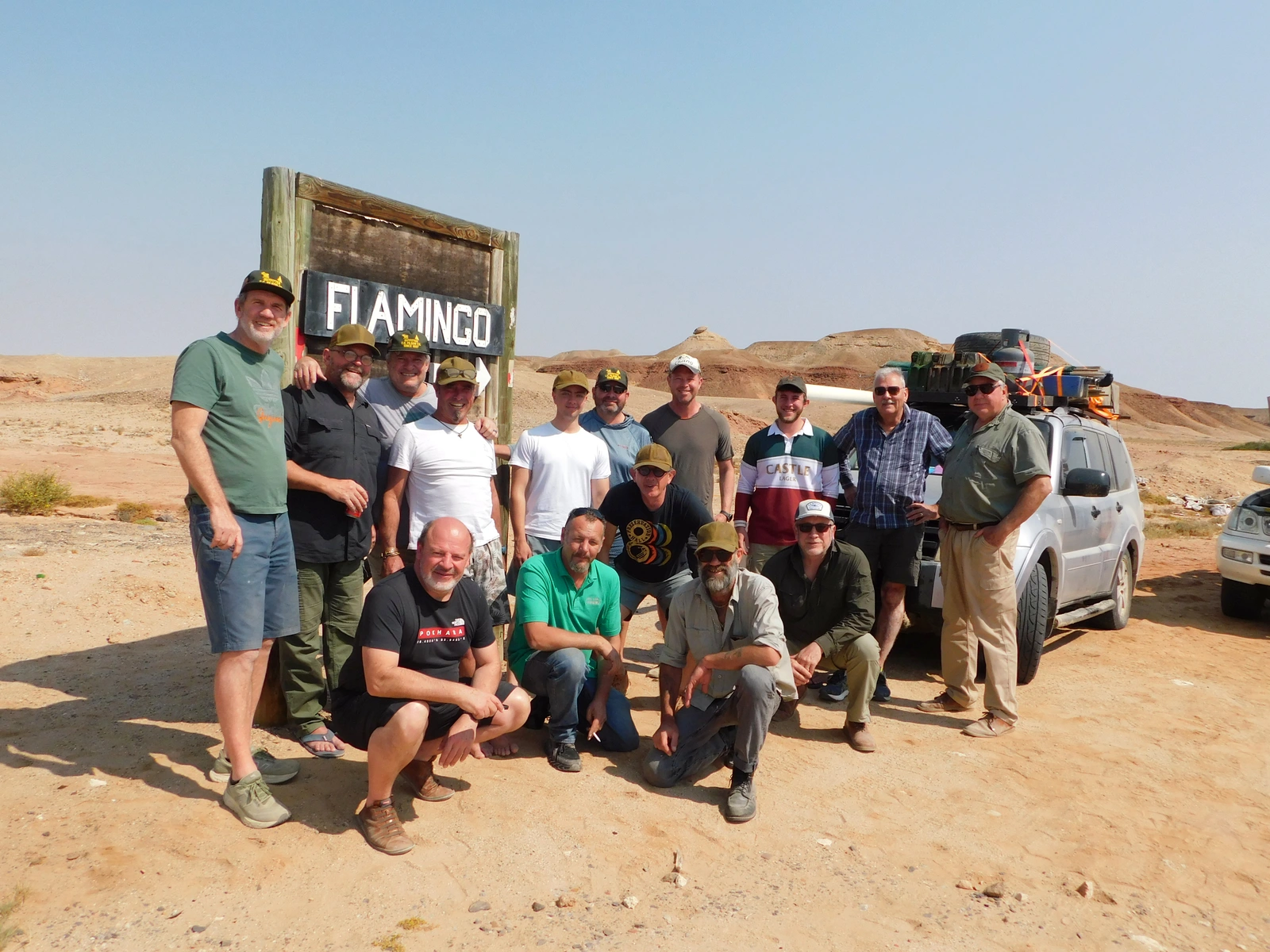 Group of travellers gathered by a Flamingo sign