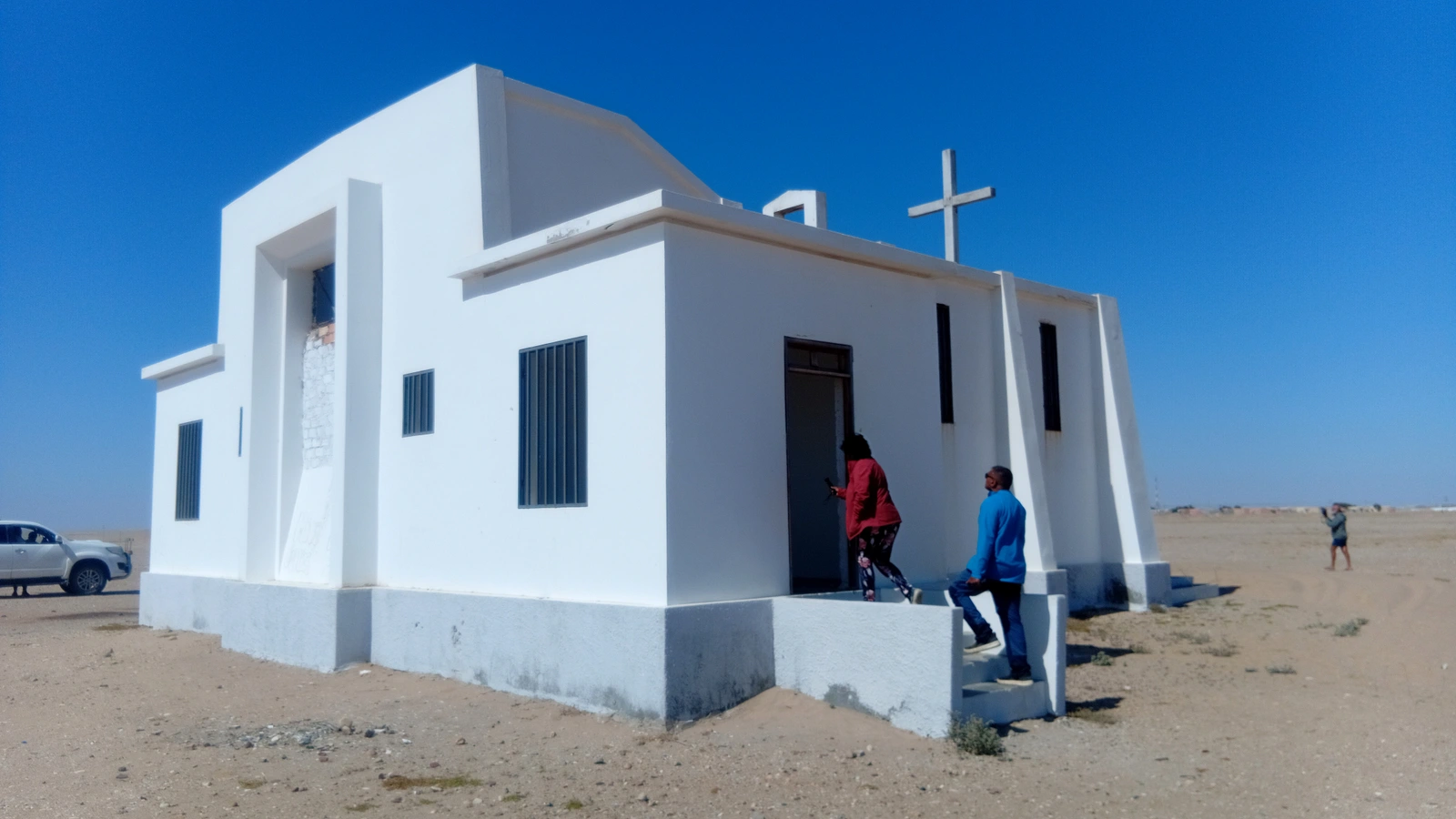 White church with travellers outside