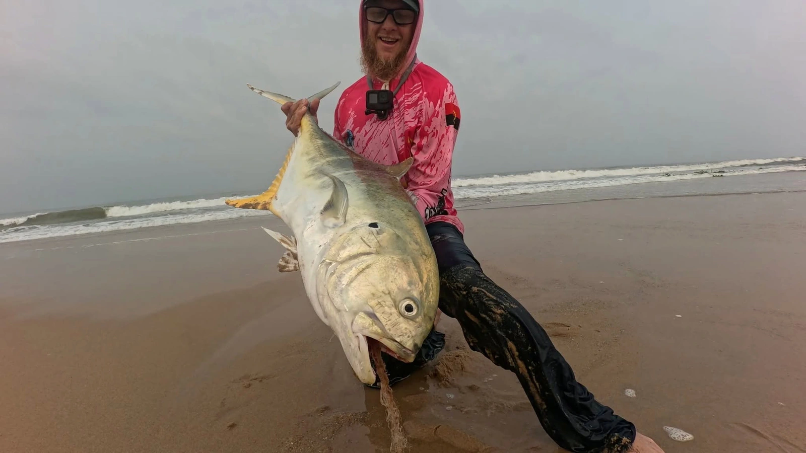 Angler holding a fish at the shoreline