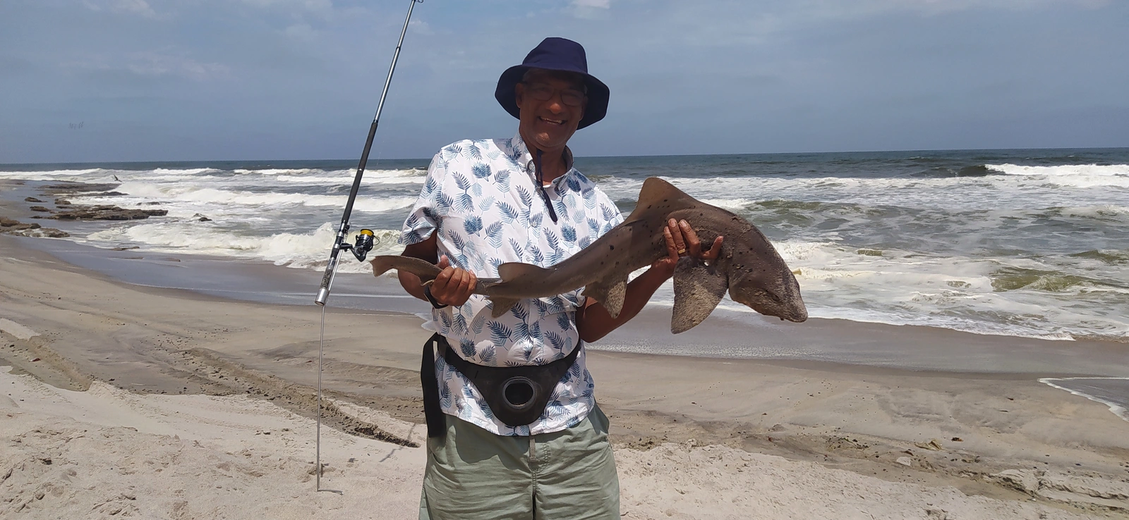Angler holding a fish by the Atlantic