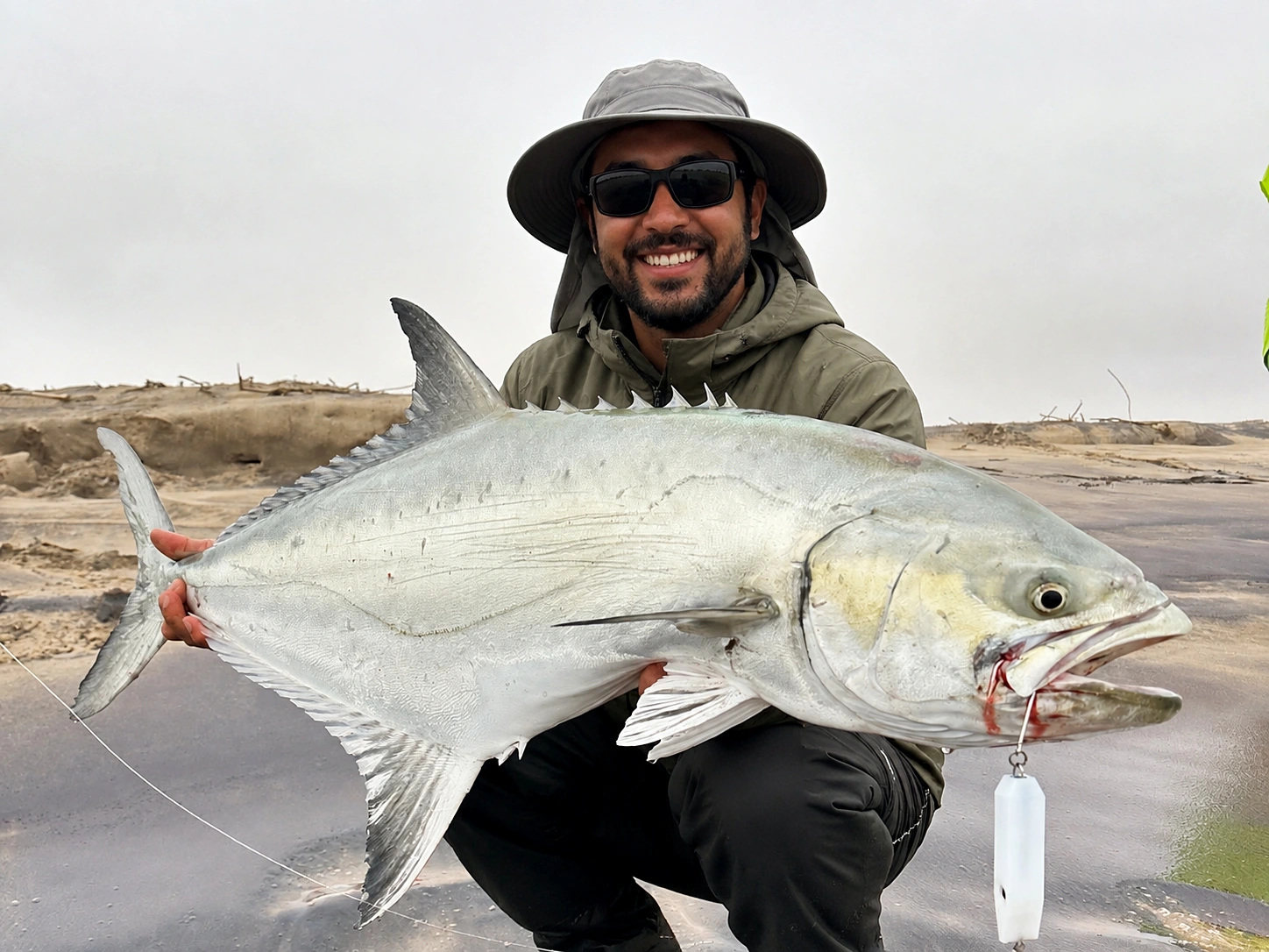 Angler holding a fish beside the surf